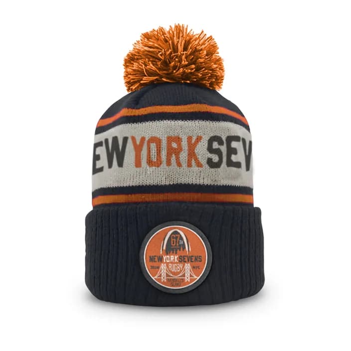 Navy, orange and white pom beanie with “New York Sevens” lettering and a round event patch